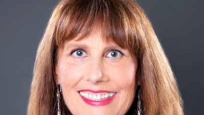Portrait of a smiling woman with brown hair and long earrings
