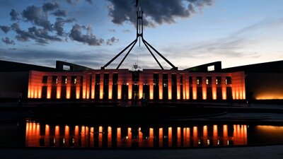 Australian Parliament House at dusk with an orange illumination