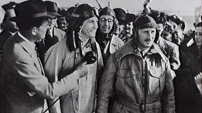 Black and white image of pilots surrounded by media