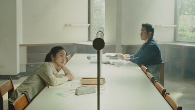 A women and a man sitting on opposite sides of the table