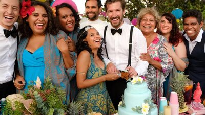 Top End Wedding Nine people pictured smiling and laughing at camera celebrating