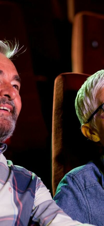 A Day at the Movies is the NFSA’s exciting new dementia-friendly film program for cinema-lovers A man sitting on left and woman on right, both sitting at the cinema looking past the camera