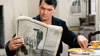 Man sits with newspaper having breakfast