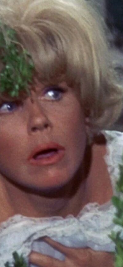 Woman looking to her left hiding behind bushes