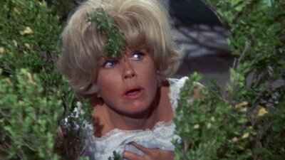 Woman looking to her left hiding behind bushes