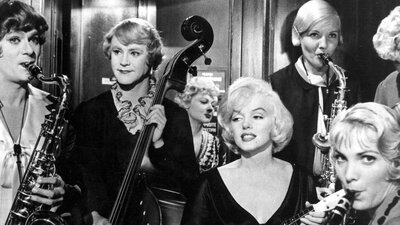 Black and white still of Marilyn Monroe surrounded by musicians