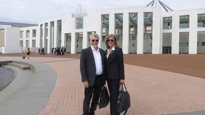Robbie Swan and Fiona Patten. A man and a woman standing in front of the Parliament House in Canberra