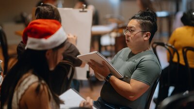 Person drawing wearing Santa hat