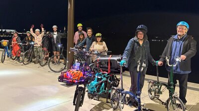 People on all sorts of bikes pause beside Lake Burley Griffin