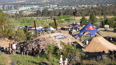 R Willy front flip no hander at Stromlo Forest Park's Hillfire BMX jumps, ACT JAM 2023 R Willy doing a front flip no hander over a big dirt jump as the crowd looks on
