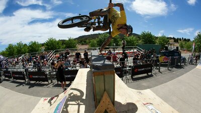 Jon Mackellar riding BMX doing a handplant over a hitching post wall at ACT JAM 2023