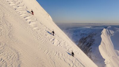 Wide shot of climbers up a snowy mountain