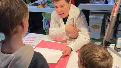 Forensic AFP personnel showing forensic science to two young boys