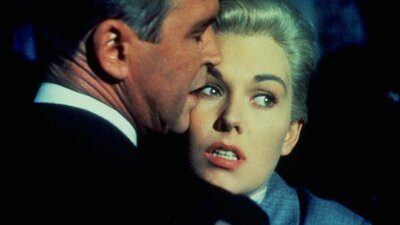 Man and woman embracing, woman faces audience, man faces away from camera