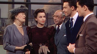 Group of five people standing in a semi circle conversing