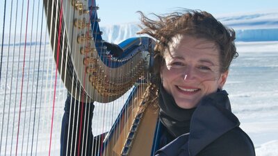 Woman playing in the harp in a snowy landscape