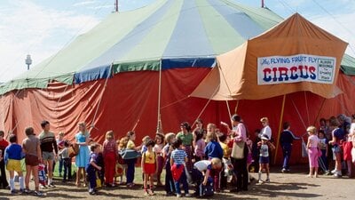 The Flying Fruit Fly Circus, 1982. NAA: A6135, K20/9/82/13 Coloured photograph of The Flying Fruit Fly Circus with crownds gathered outside the circus tent