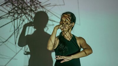 a dancer wearing black with black projected lines on her body