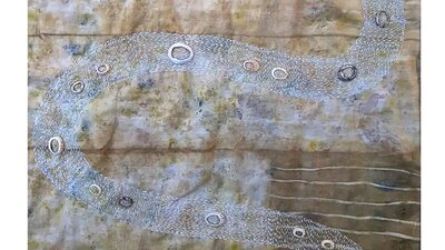 brown and white textile with snake embroidery