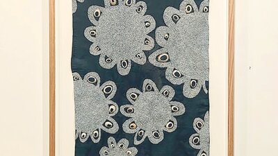 Blue textile with white embroidered flowers and shells