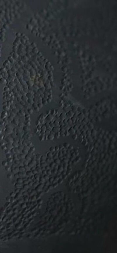 Dark round ceramic urn with dot texture