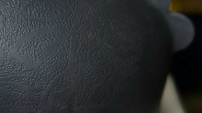 Dark round ceramic urn with dot texture