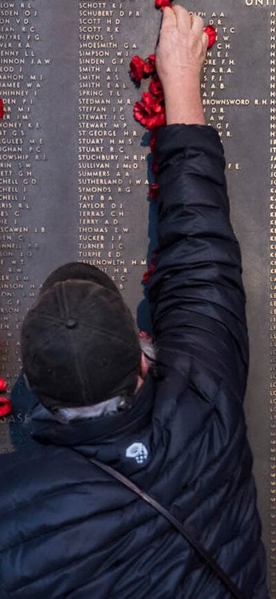 man places poppy on Roll of Honour