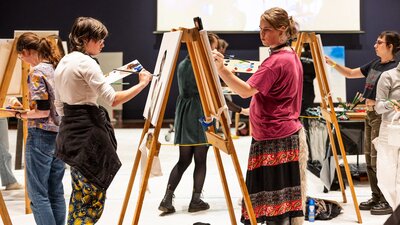Art Live: All Stars. April 2024. National Gallery of Australia. Kamberri/Canberra A room of young people painting portraits on large canvases sitting on easels.