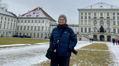 Hilary Wardhaugh with her camera, in a snowy courtyard flanked by historical buildings.