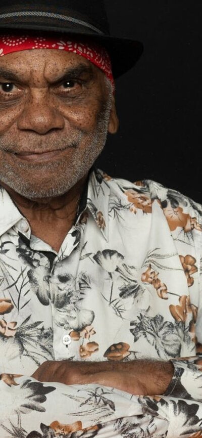 Warren H Williams smiling at camera with a red bandana and black hat