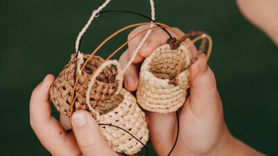 Hands holding small weaving objects