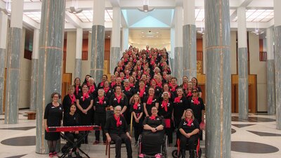A large choir standing on the steps inside the Marble Foyer