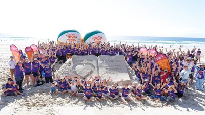 Australian Transplant Games attendees around a sand sculpture that reads "thank you - donatelife"