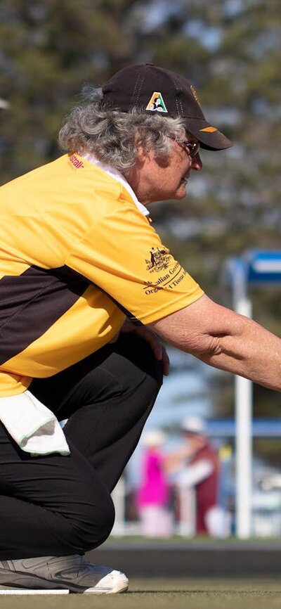 woman in yellow shirt playing lawn bowls