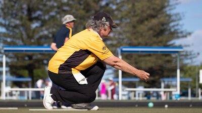 woman in yellow shirt playing lawn bowls