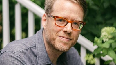 A man wearing glasses and a dark grey shirt