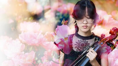 Young female violinist pictured in front of floral background