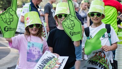 Young fans pose for a photo with Sydney Thunder giveaways at Manuka Oval