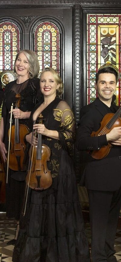 Classical musicians pictured in a grand old house/