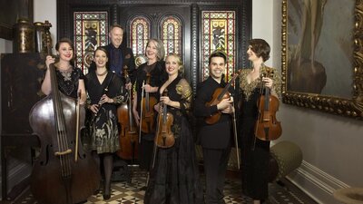 Classical musicians pictured in a grand old house/