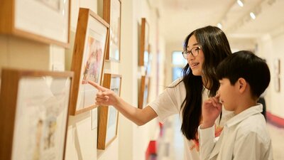 Children view artwork in gallery.