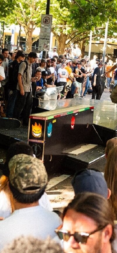 Skateboarder performs nose manual in front of crowd in Canberra city