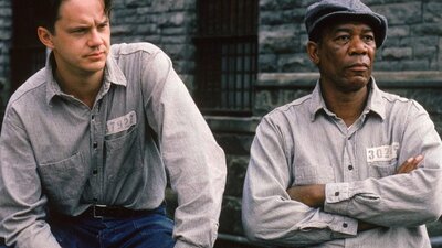 Two men dressed in prison shirts