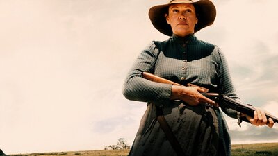 Still from The Legend of Molly Johnson showing a woman holding a rifle