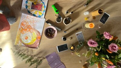 Overhead view of breathwork space with seasonal flowers, creative materials, journals, natural items