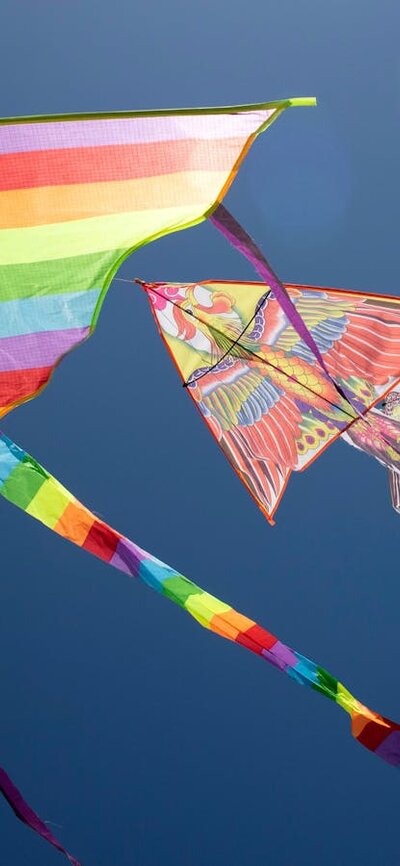 Two colourful kites flying in the blue sky