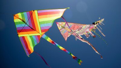 Two colourful kites flying in the blue sky