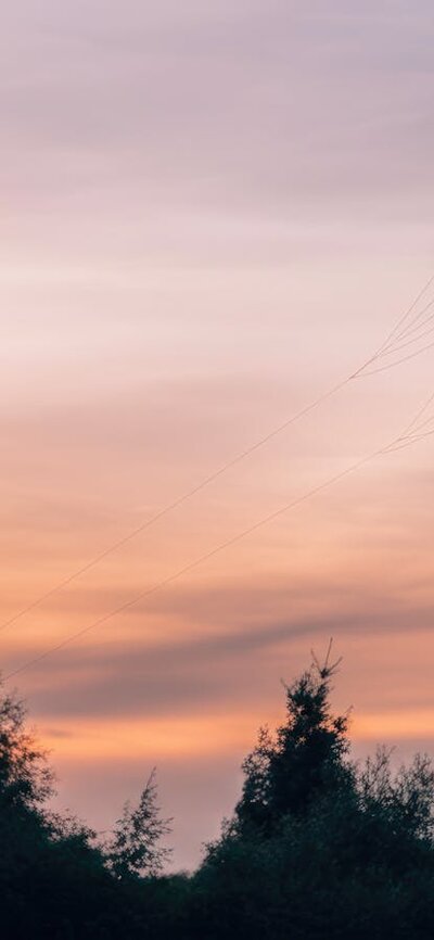 Man flying kite at sunset in scenic landscape