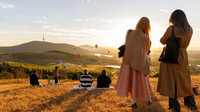 People up at lookout location to watch the balloons float over the Canberra skyline