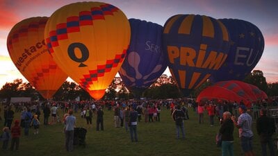 Different coloured balloons about to lift off